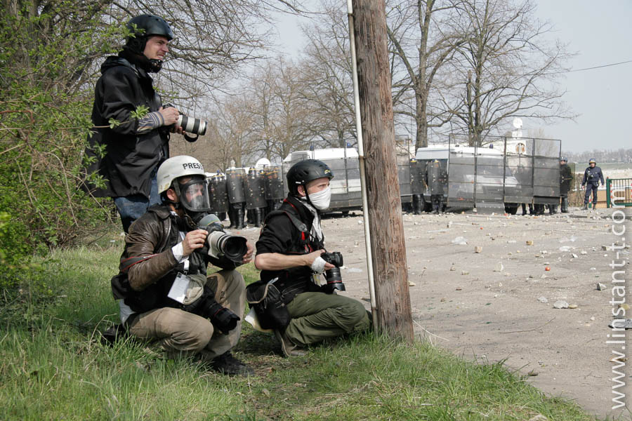 Photographes casqués pendant une manifestation violante